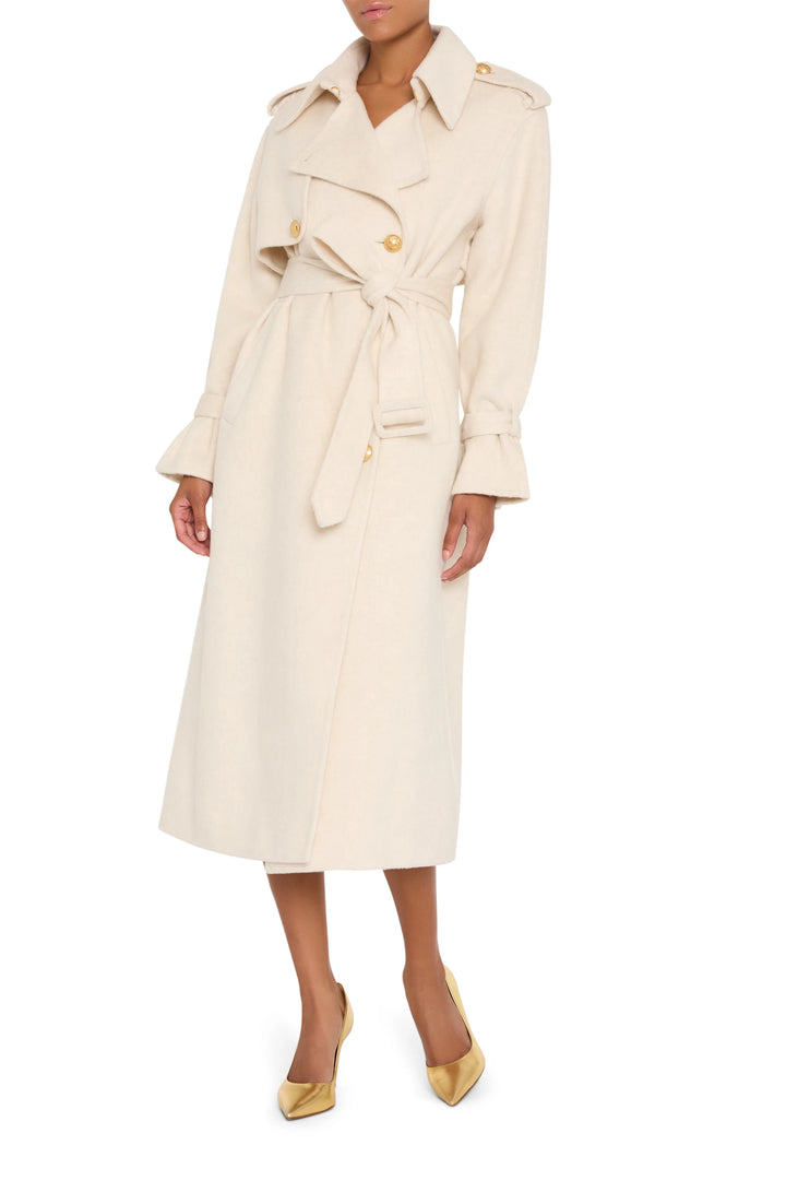 Silk wool trench coat with tailored silhouette, gold buttons, structured collar; front view on model.
