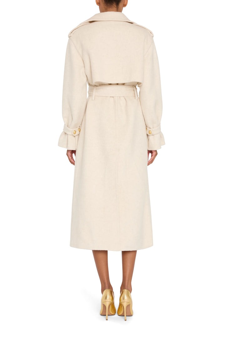 Long tailored trench with structured shoulders, back vent, and belted waist in silk wool; back view on model.