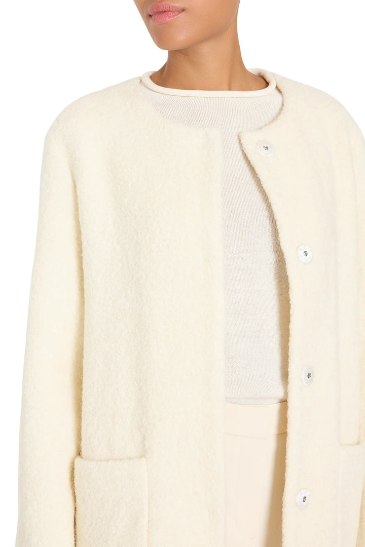 Textured bouclé coat with clean silhouette, tailored construction, minimal details; front view on model.