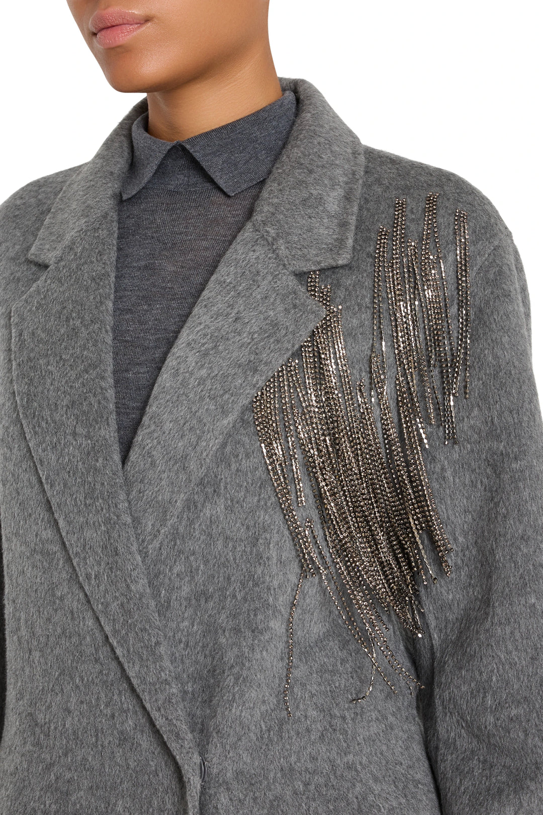 Long wool-blend coat with straight silhouette, notch collar, seamed construction, subtle embellishments; front view on model.