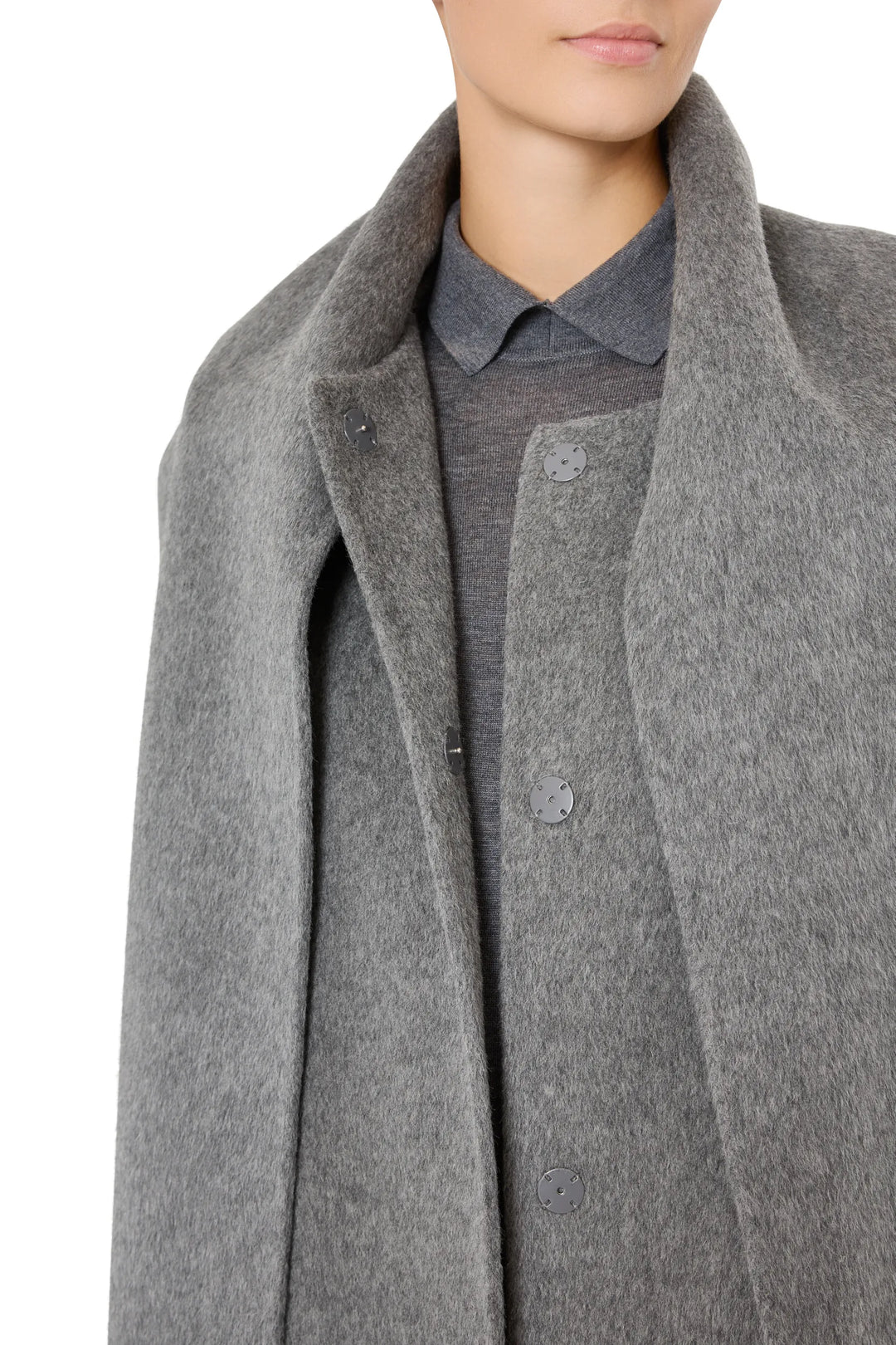 Wool coat with sculptural shoulders, detachable scarf, structured silhouette; front view on model.