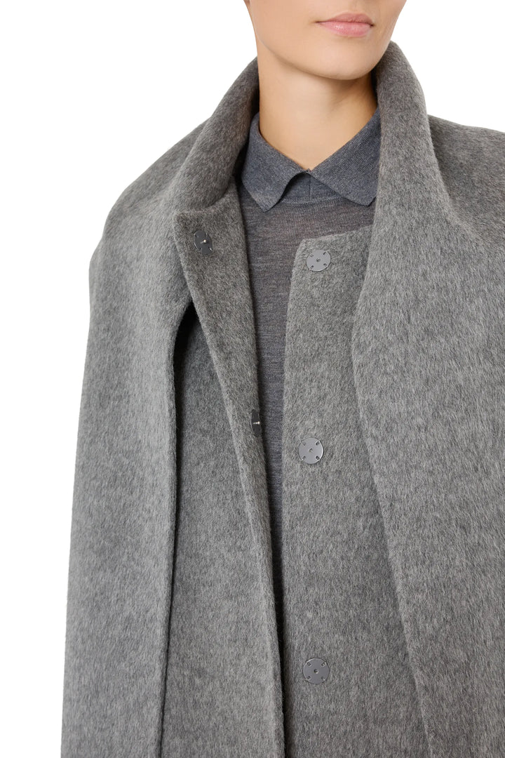 Wool coat with sculptural shoulders, detachable scarf, structured silhouette; front view on model.