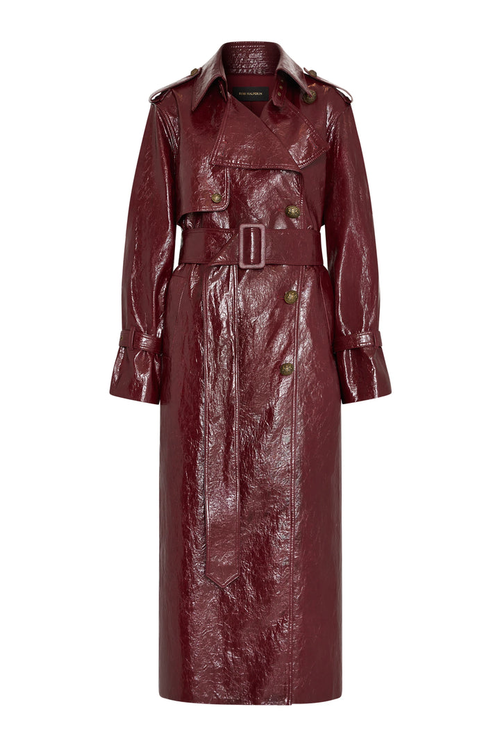 Glossy vegan trench coat with wide lapels, military hardware, buttons, and belt. Front view on white.