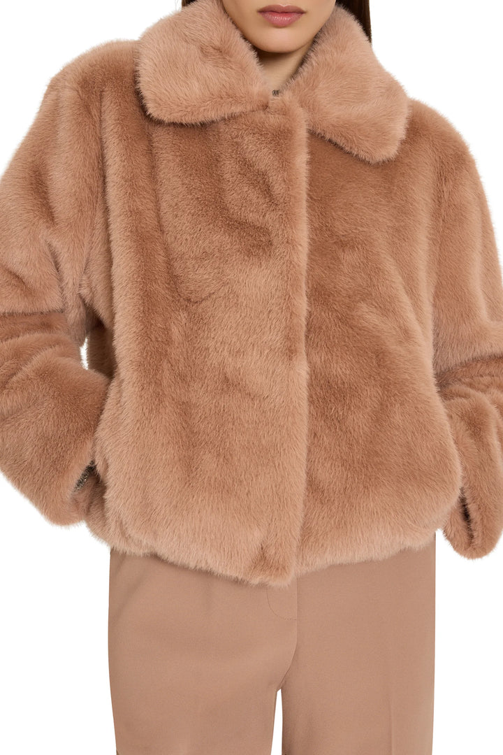Short faux fur coat with relaxed silhouette, jeweled embellishments, collar, front closure; front view on model.