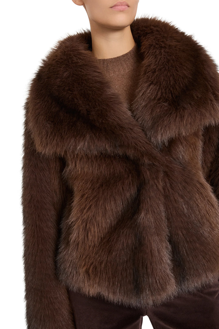 Boxy faux fur short coat with notch collar and concealed closure, hip length. Front view on model.