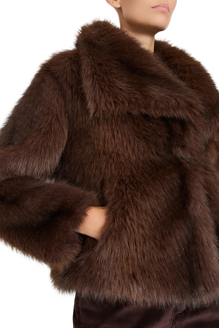 Short faux fur coat, shawl collar, hip length, relaxed fit. Front view on model.