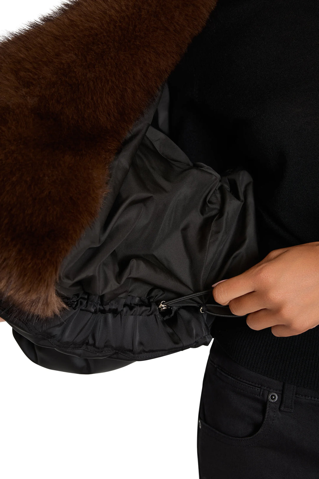 Nylon coat with faux fur, features zippered pocket and visible waist seam; detail view.