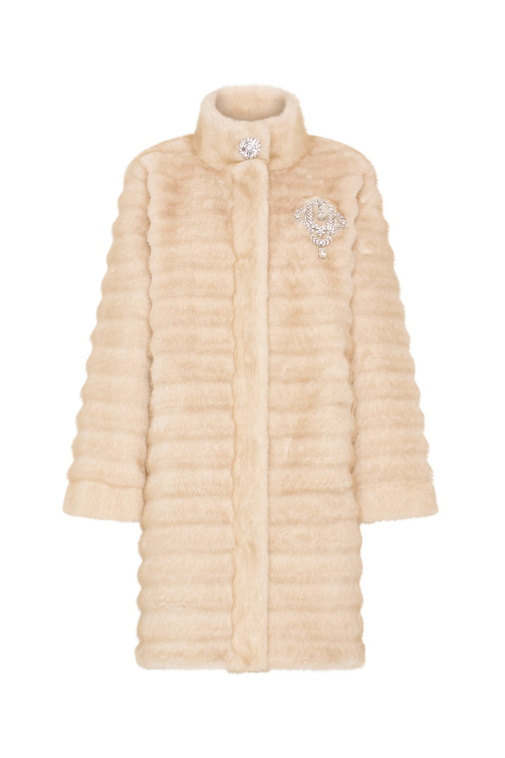 Long faux fur coat with horizontal stripes, jeweled chest brooch, relaxed silhouette. Front view on white.