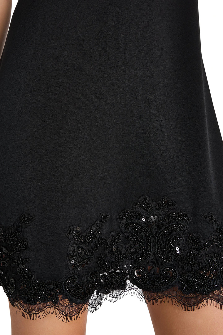 Black crepe mini slip dress with ornate lace, tonal embroidery, and sequin hem; front view on white.