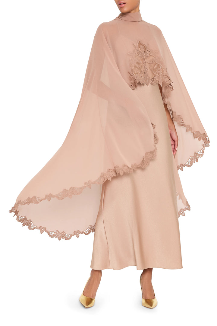 Floor-length dress with draped cape, fitted bodice, and fluid skirt in woven fabric; front view on model.