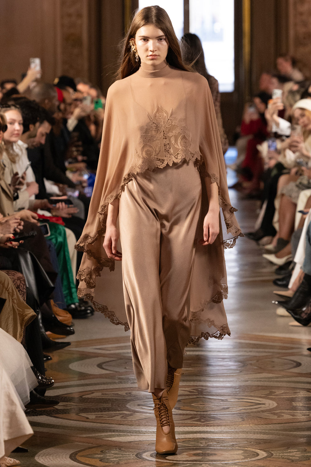 The Carmen Long Dress With Cape features a flowing silhouette and cape detail. Front view on model.