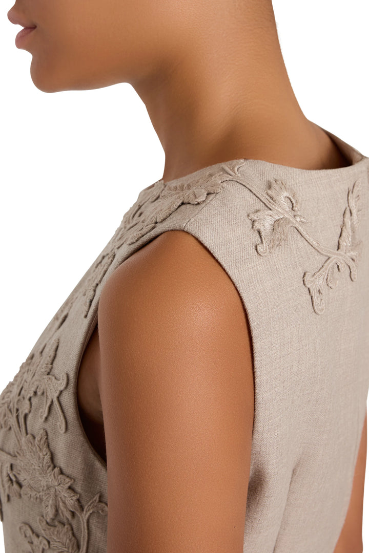Fit-and-flare dress with floral embroidery, soft tailoring, structured waist, flared skirt; side view on model.