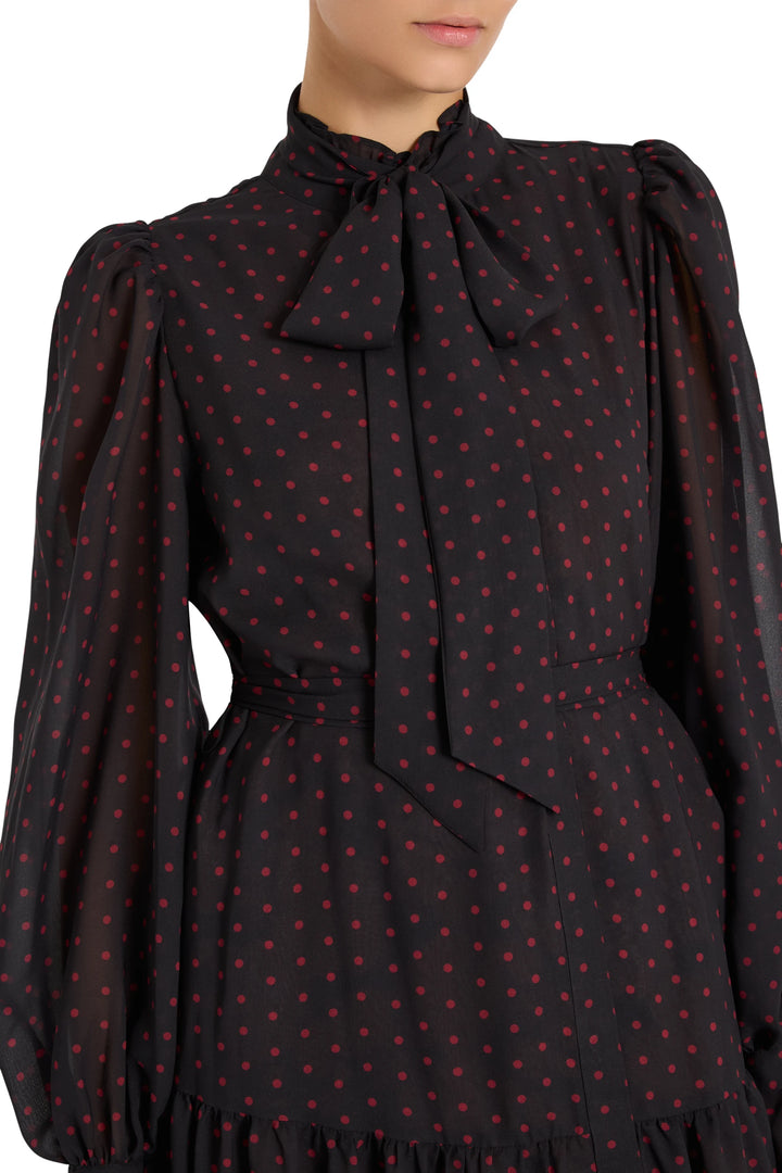 Midi chiffon dress with puff sleeves, fitted bodice, flared skirt; red polka dots. Front view on model.
