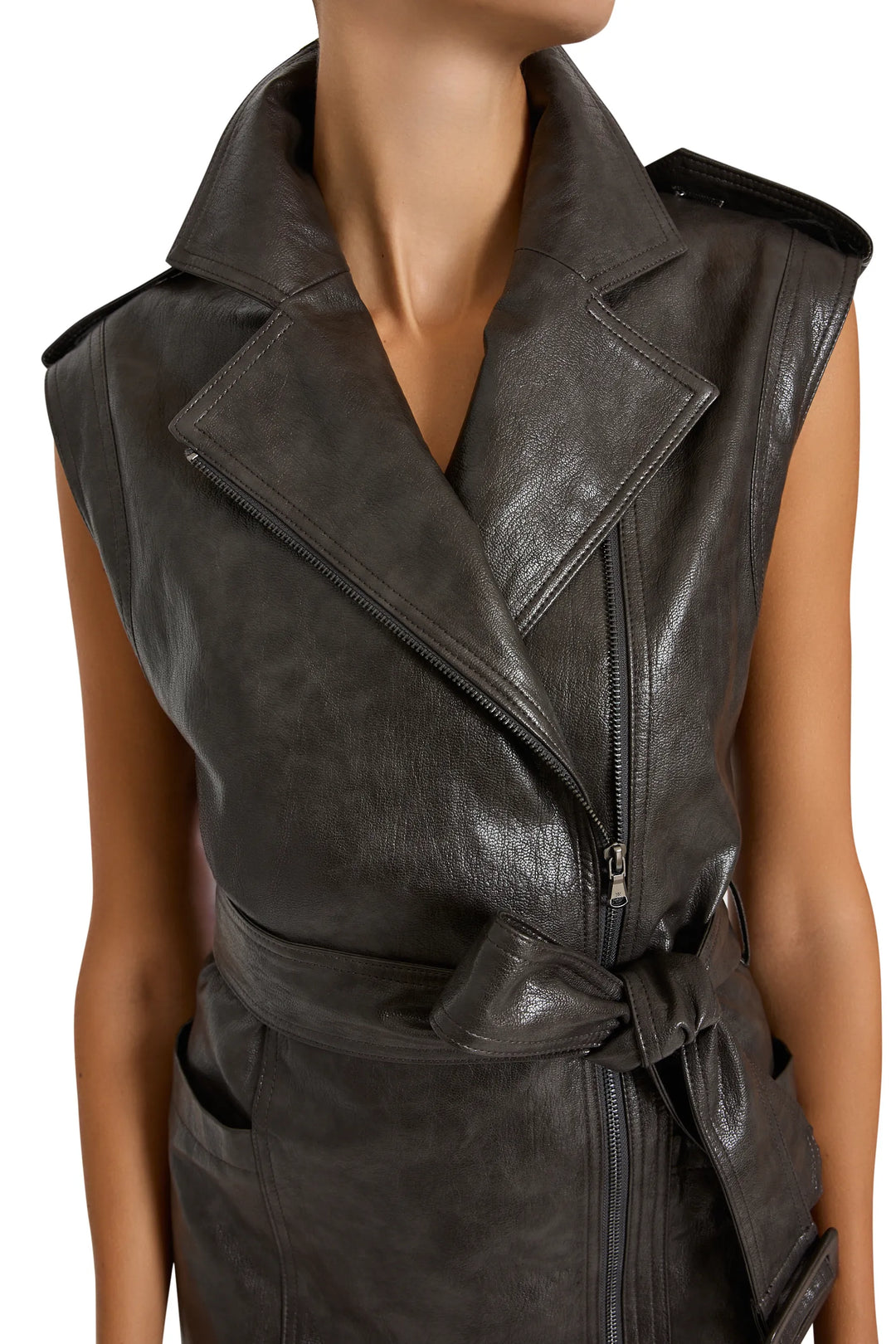 Vegan leather trench dress with wide lapels, asymmetrical zip, bold belt; tailored silhouette, front view on white.