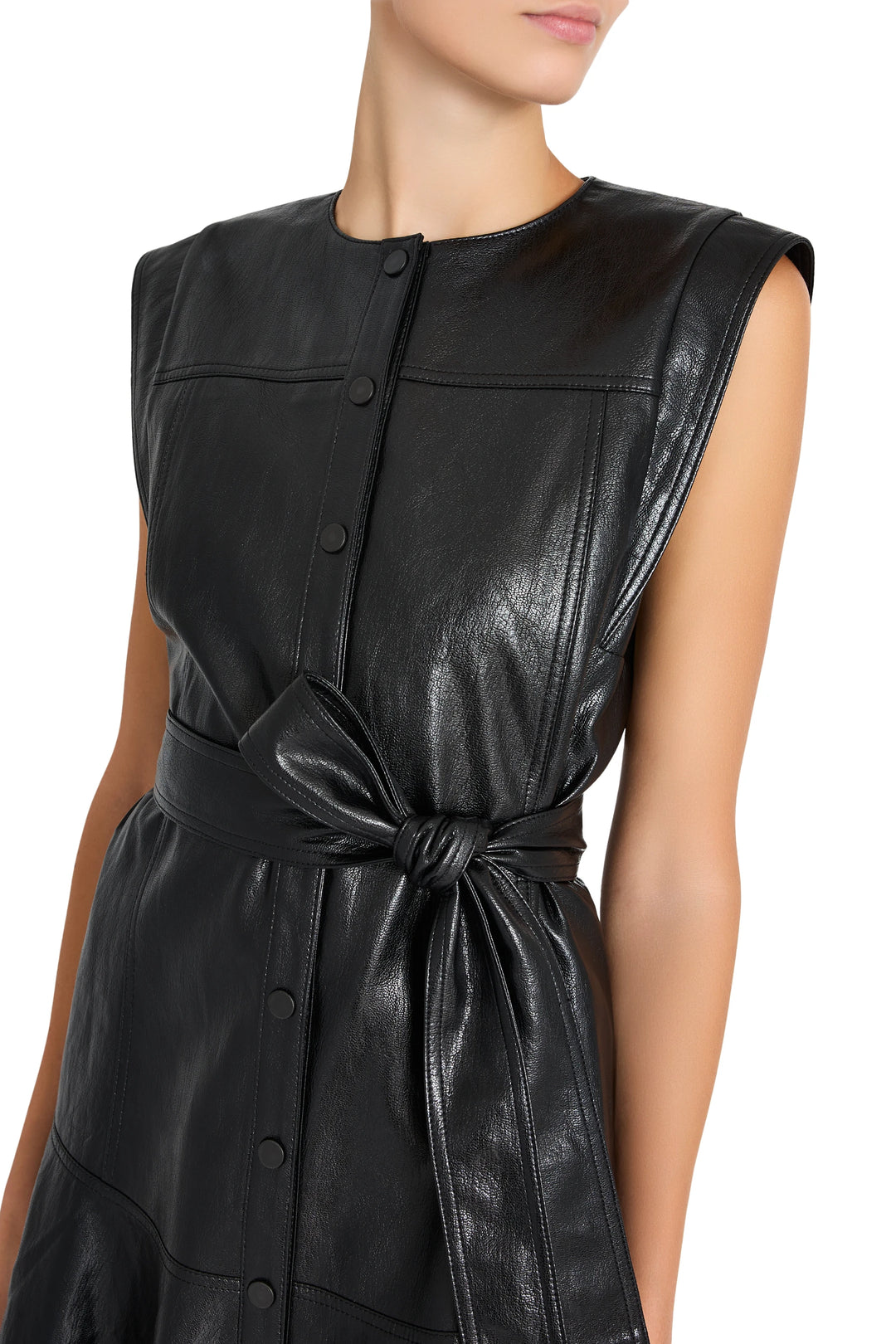 Sleeveless vegan leather dress with front buttons, tied waist belt, straight silhouette; front view on model.