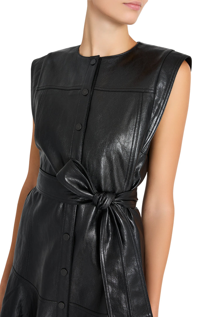 Sleeveless vegan leather dress with front buttons, tied waist belt, straight silhouette; front view on model.