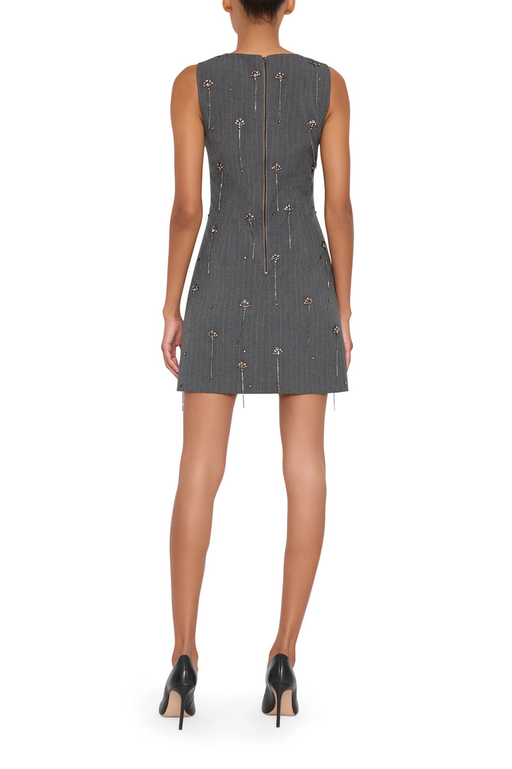 Mini dress with fitted silhouette, embellished detailing, structured waist, and short hem; back view on model.