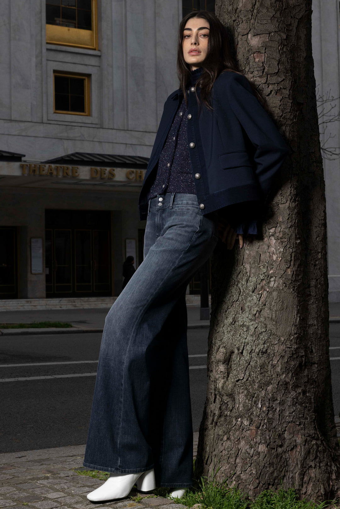 Wide-leg denim trousers with classic five-pocket construction; front view on model, editorial setting.