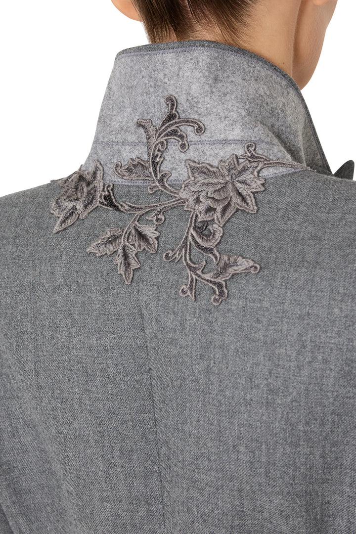 Detail of flannel blazer’s back collar with dark gray floral embroidery stitching, detail view.