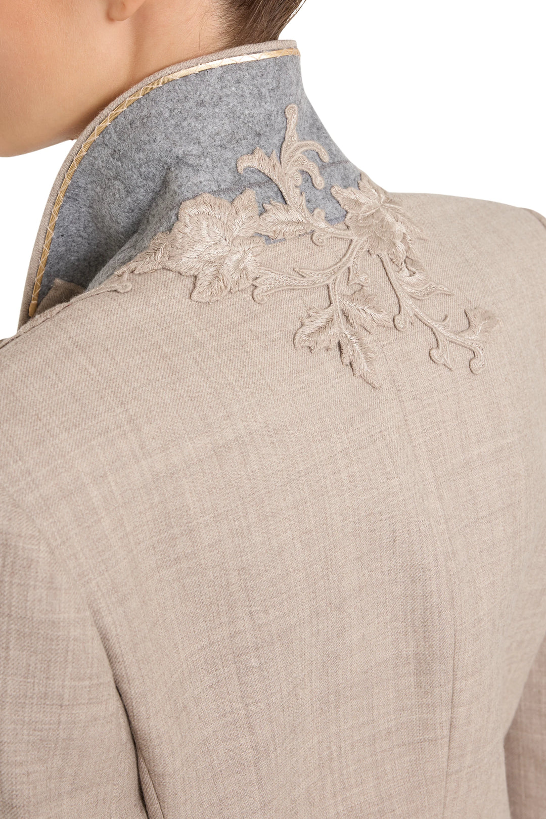 Detail of floral embroidery on flannel blazer’s raised light grey collar; intricate stitching. Detail view.