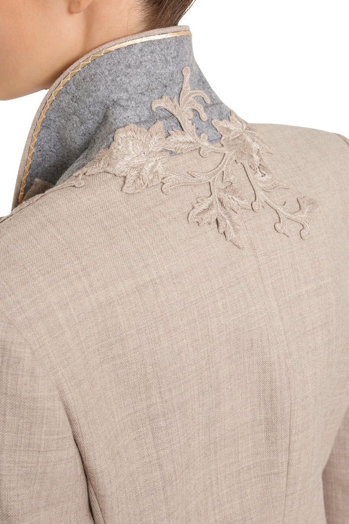 Detail of floral embroidery on flannel blazer’s raised light grey collar; intricate stitching. Detail view.