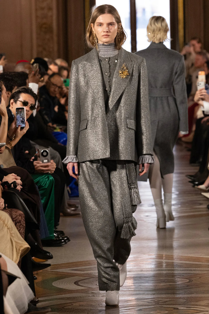 Shimmering wide-leg suit with tailored construction, fluid drape. Editorial setting on model.