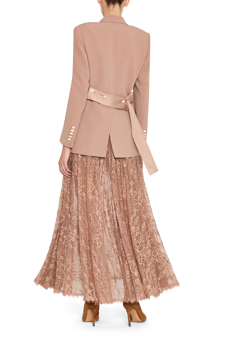 Tailored crepe blazer with belted waist, structured shoulders, peak lapels. Front view on model.