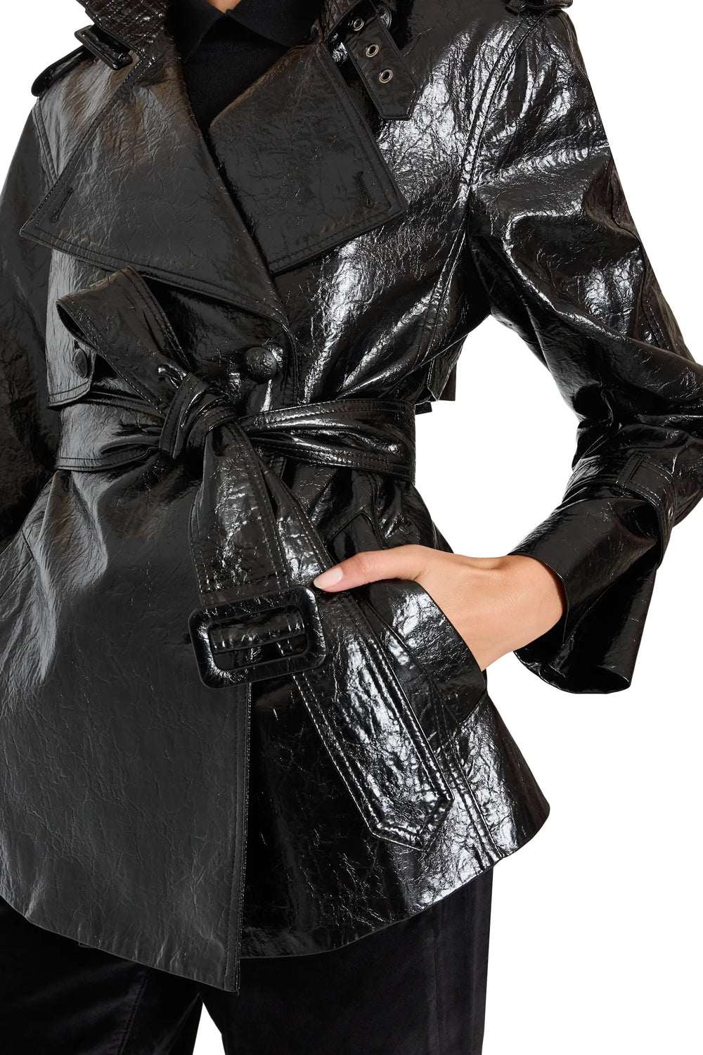 Cropped trench with structured silhouette and classic lapel in vegan leather, waist pockets. Front view on model.