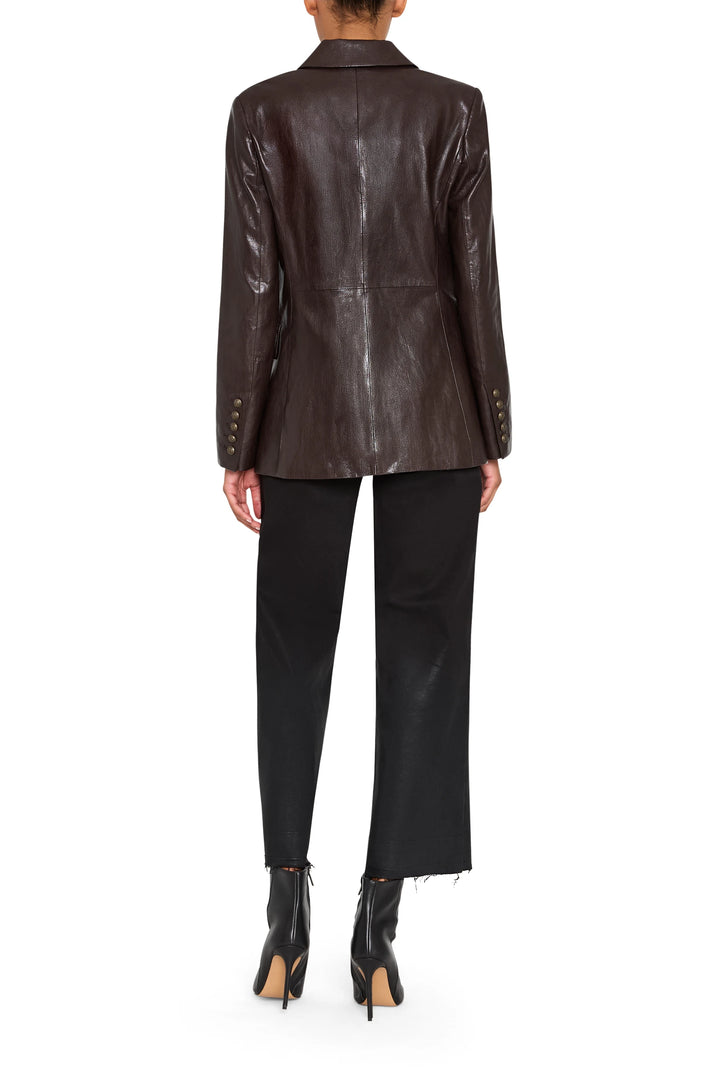 Tailored double-breasted vegan leather blazer with structured shoulders, notched lapel; front view on model.