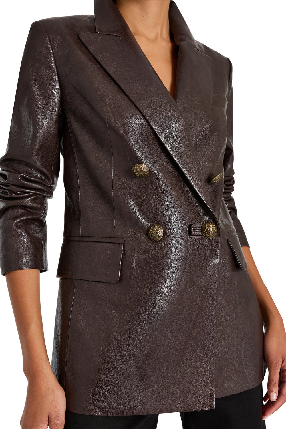 Double-breasted vegan leather blazer, military buttons, structured fit, peak lapels; front view on model.