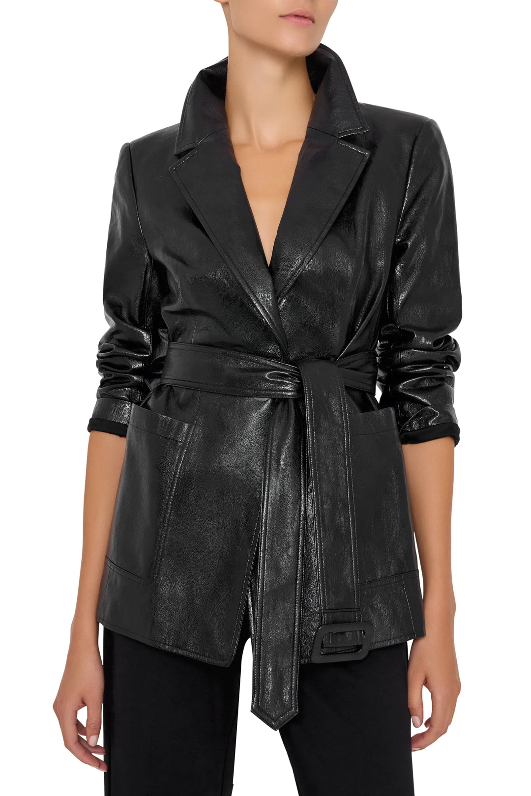 Tailored vegan leather blazer with long sleeves, notch lapel, and removable belt. Front view on model.