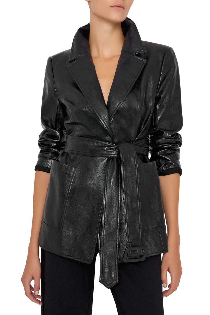 Tailored vegan leather blazer with long sleeves, notch lapel, and removable belt. Front view on model.