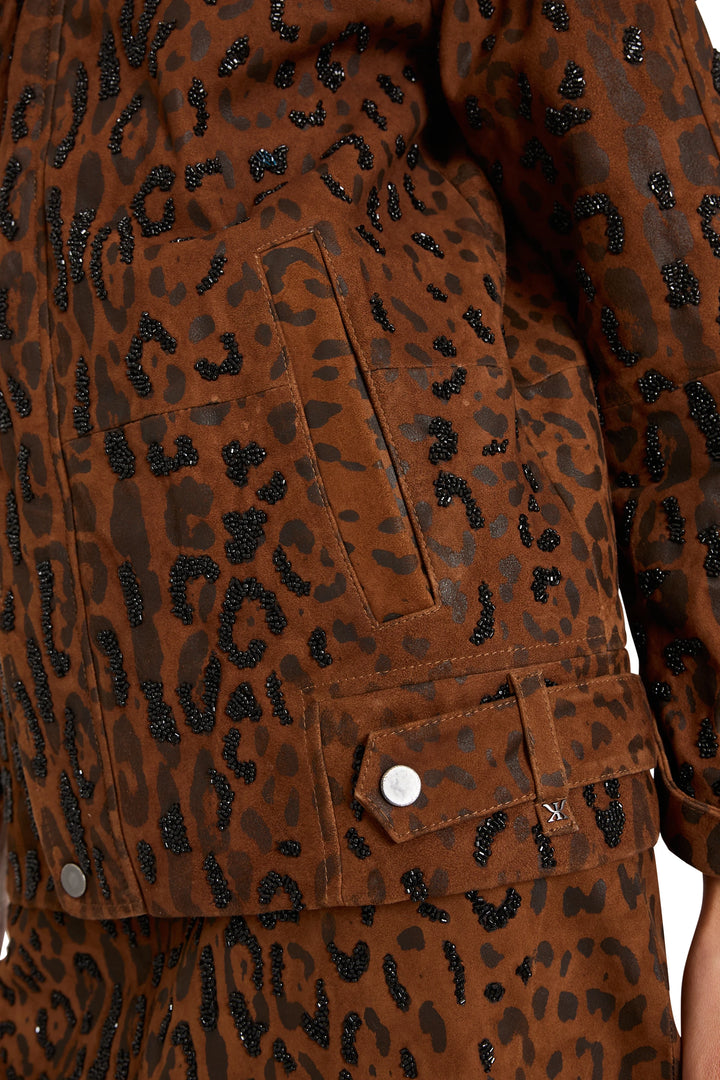 Beaded suede fabric with leopard motif, metal snap buttons and topstitching details; detail view.
