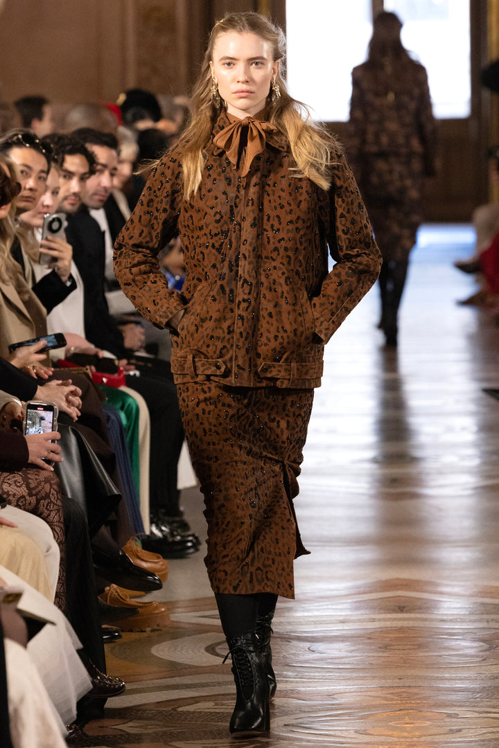 High-waisted leopard suede skirt, A-line silhouette, exposed seams; front view on model.