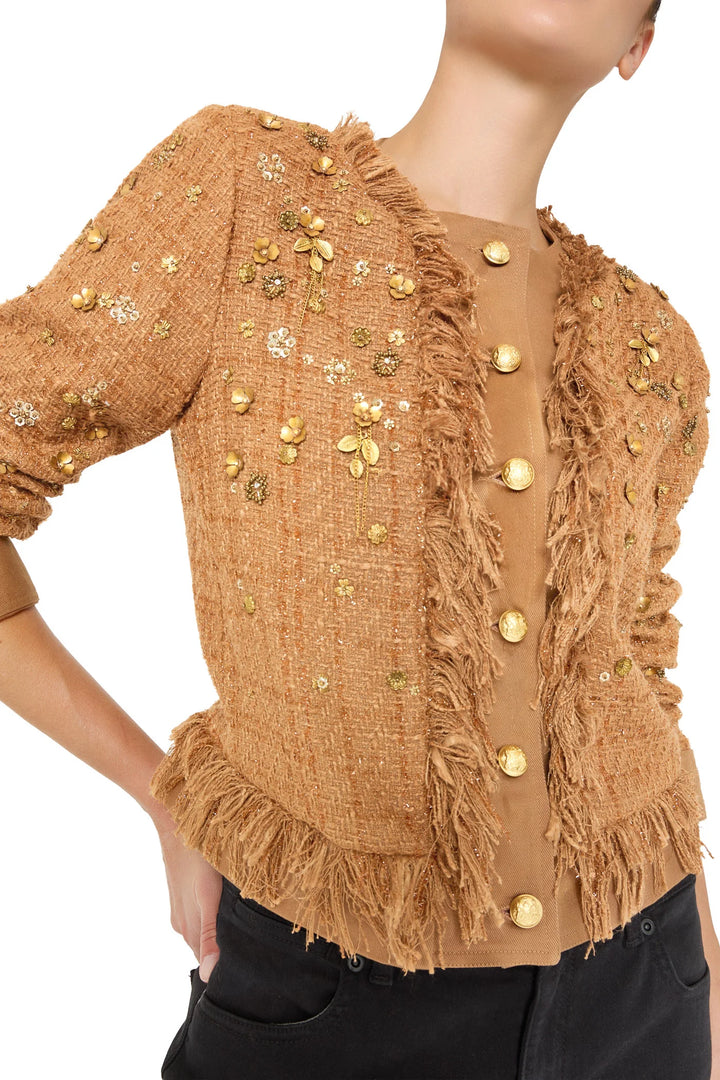 Structured tweed jacket with gold buttons and floral embroidery, tailored silhouette. Front view on model.