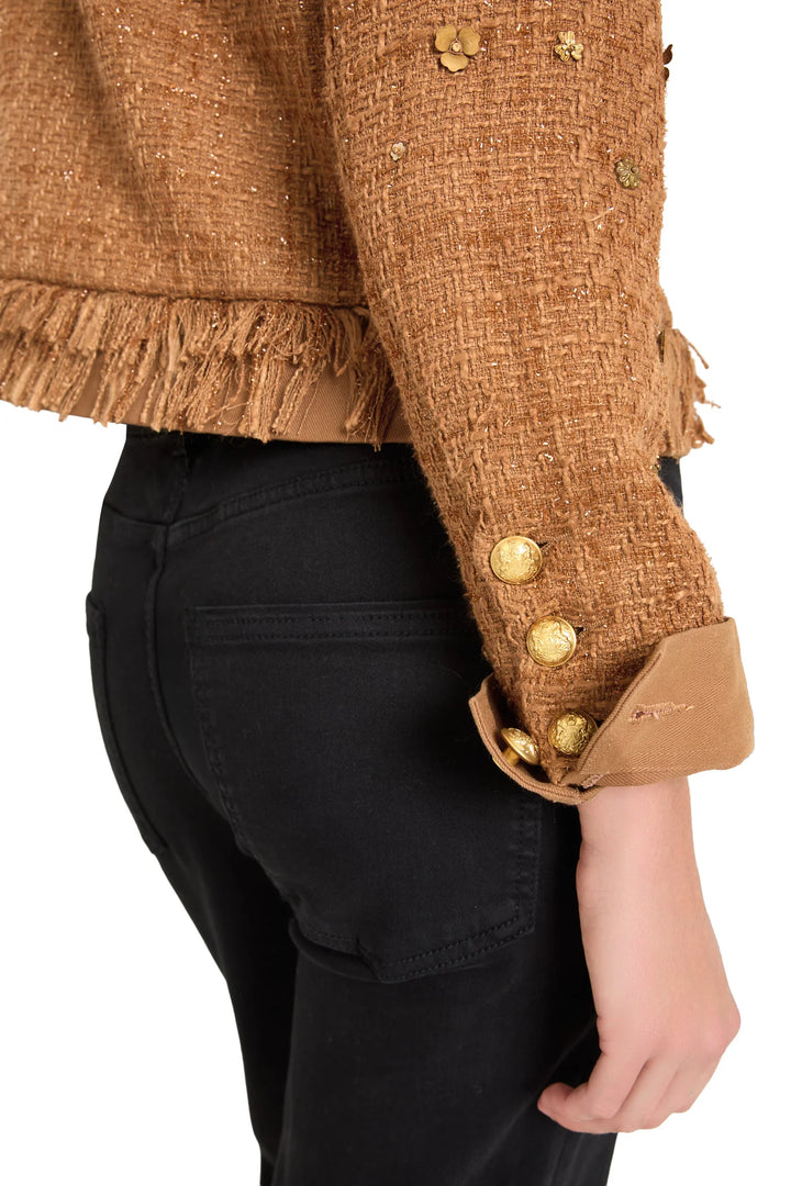 Fitted tweed jacket with metallic embroidery, gold buttons, and fringe at sleeve and hem; front view on model.