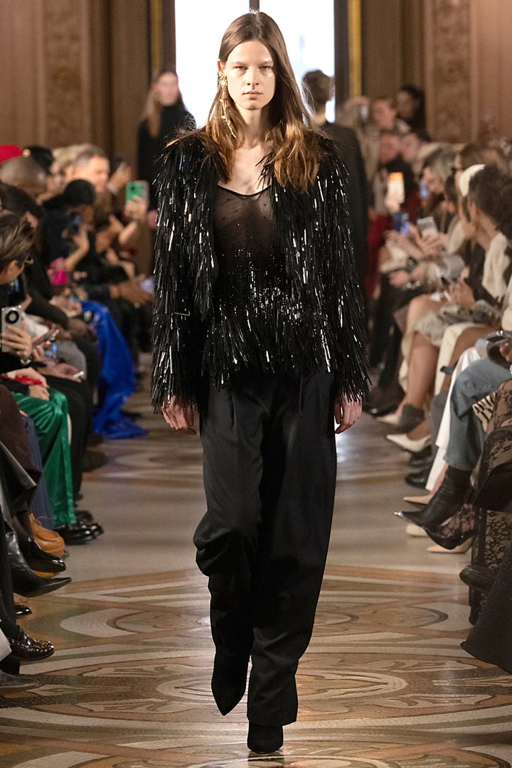 Sleeveless blouse with embellished front, relaxed fit, and round neckline. Front view on model.
