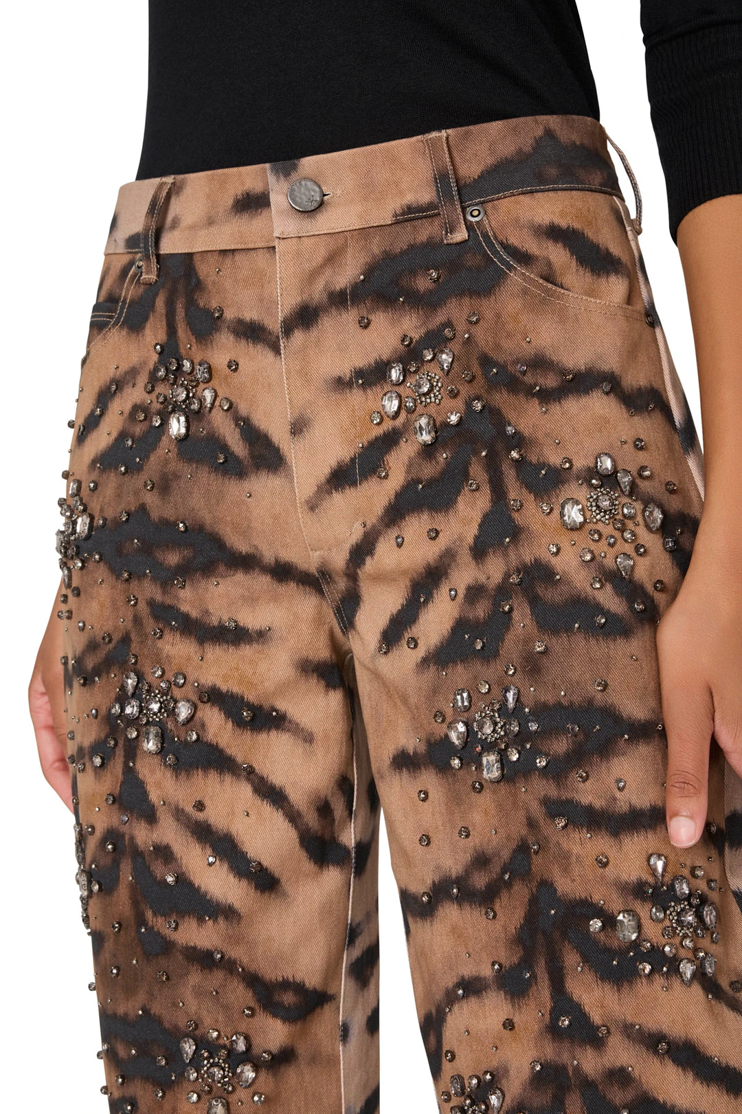 Wide-leg denim pant with tiger motif, rhinestone and bead embellishments, hand in pocket; front view on model.