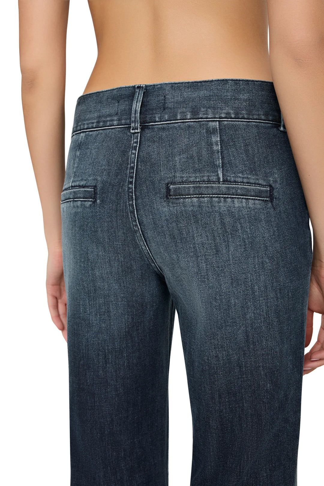 High-waisted denim with visible back pockets, structured silhouette; back view on model.