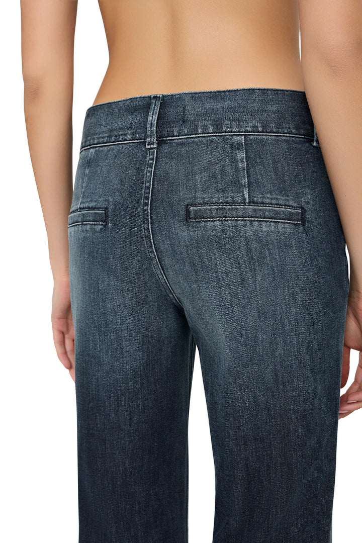 High-waisted denim with visible back pockets, structured silhouette; back view on model.