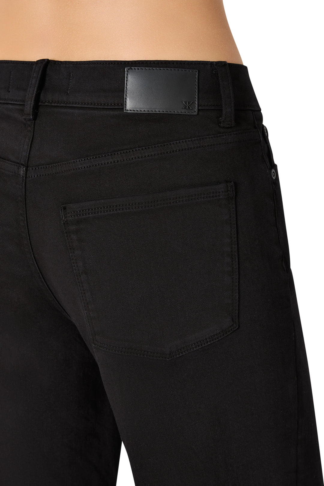 Detail of Rafaella Cropped Coated Jean: coated denim waistband, pocket seam, brand label, waxed hem; detail view.