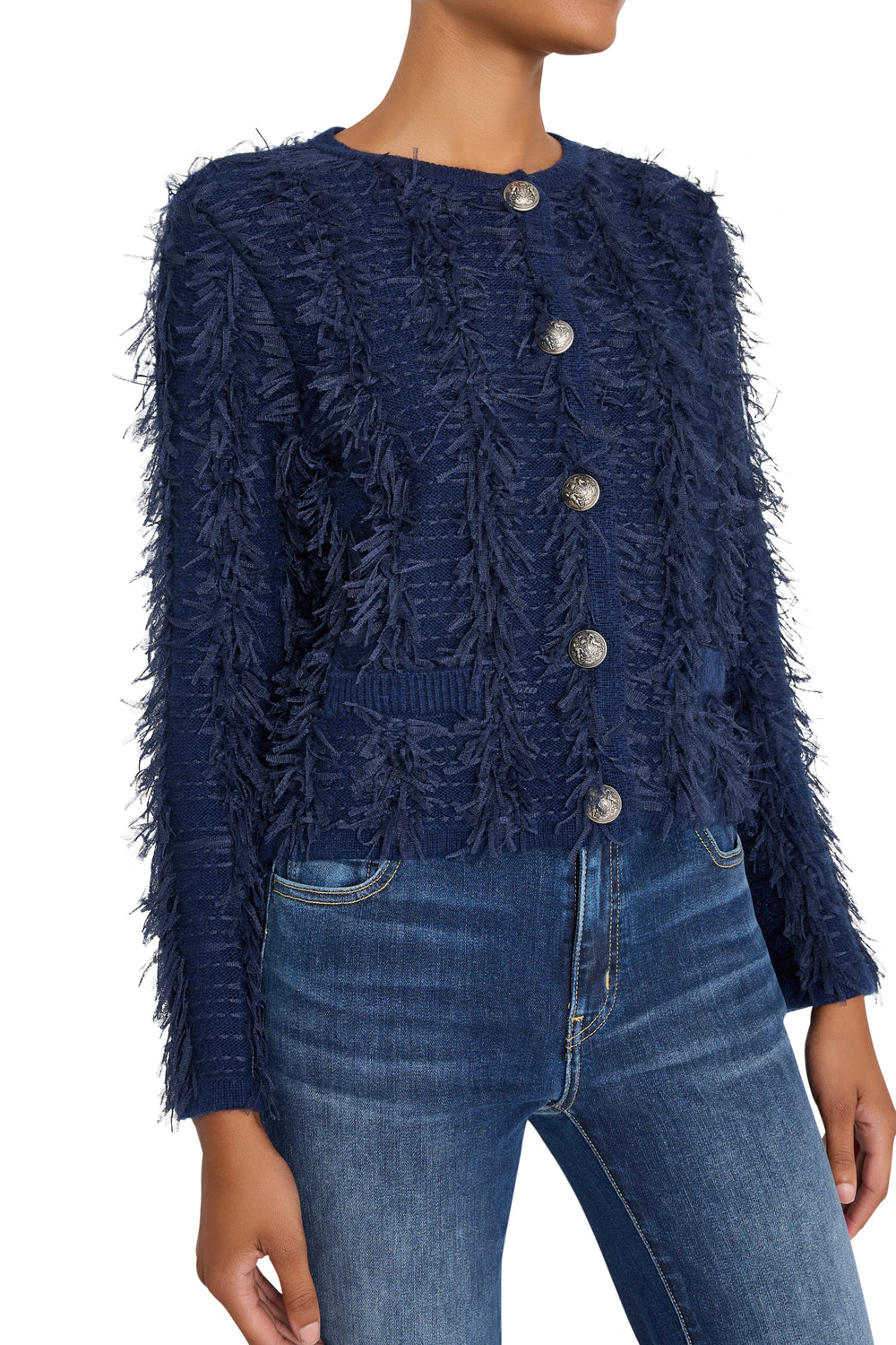 Boxy cardigan with fringe edges, silver buttons, and tweed texture. Front view on model.
