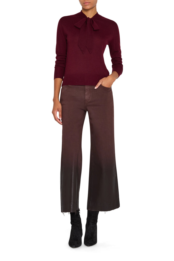 Tie neckline sweater with relaxed fit, long sleeves, and ribbed hem. Front view on model.