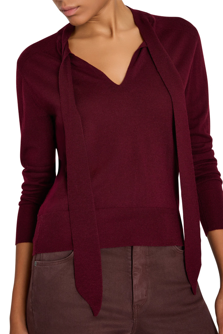 Relaxed-fit sweater with tie neckline, long sleeves, and soft knit texture; front view on model.