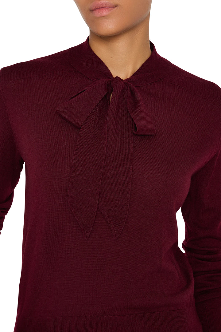 Relaxed-fit sweater with tie neckline and ribbed cuffs, knit fabric; front view on model.