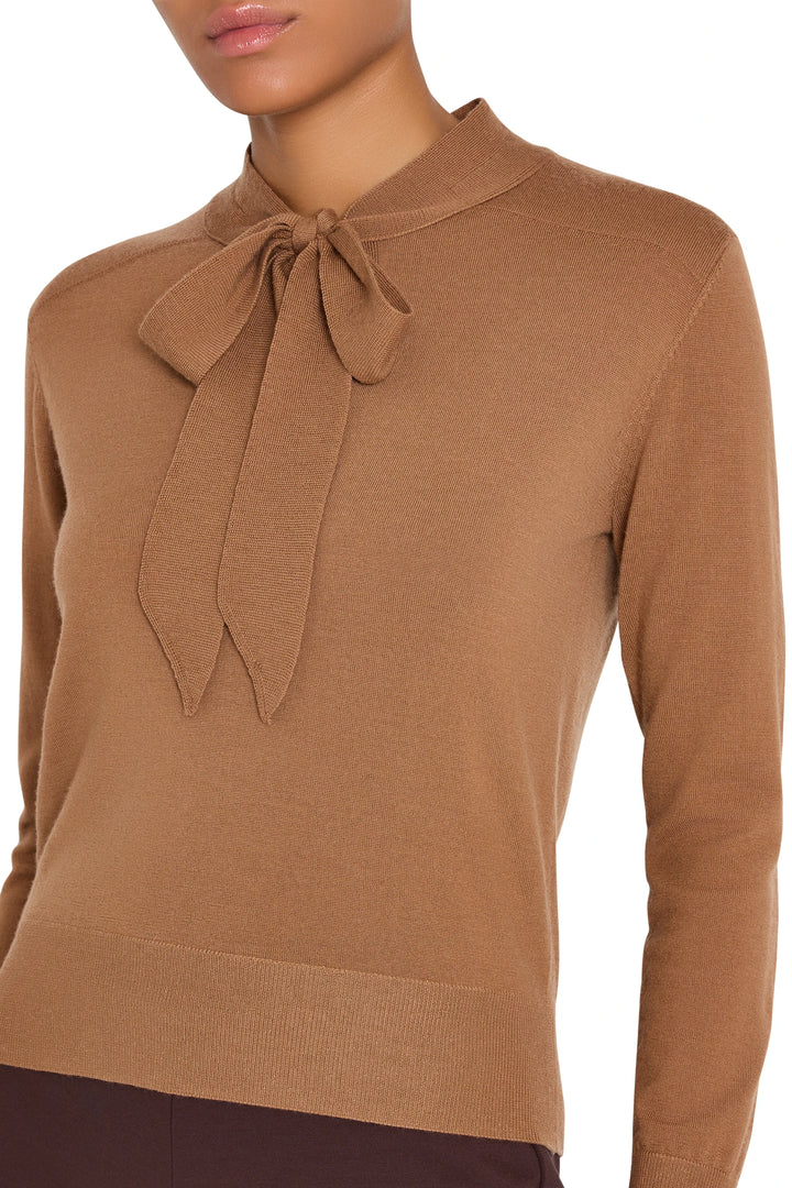 Cropped sweater with tie neckline, long sleeves, and ribbed hem in knit fabric; front view on model.
