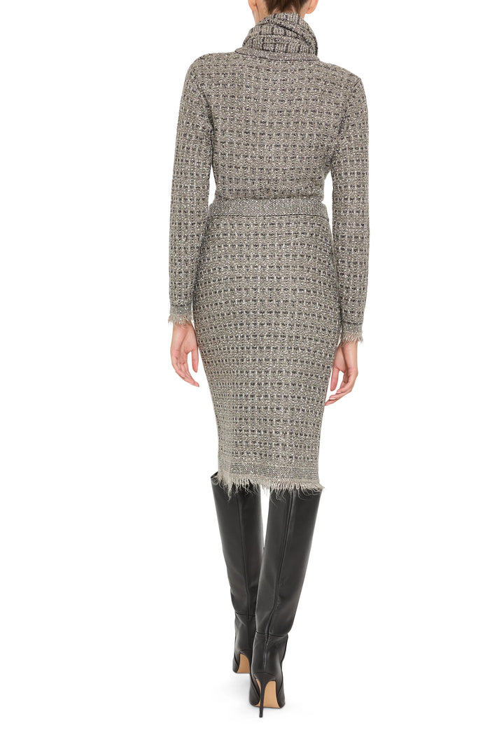 Slim tweed skirt with structured waistband and subtle back slit, tailored silhouette; back view on model.