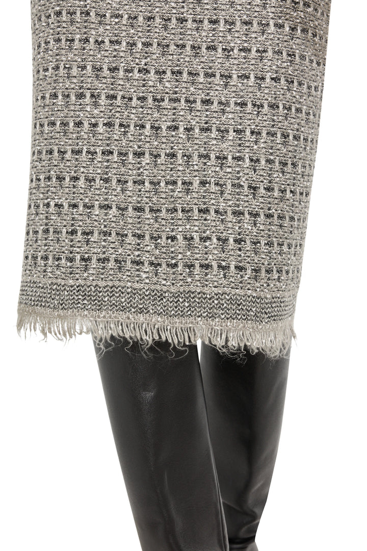 Straight silhouette sweater skirt with tweed texture and frayed hem, midi length; front view on model.