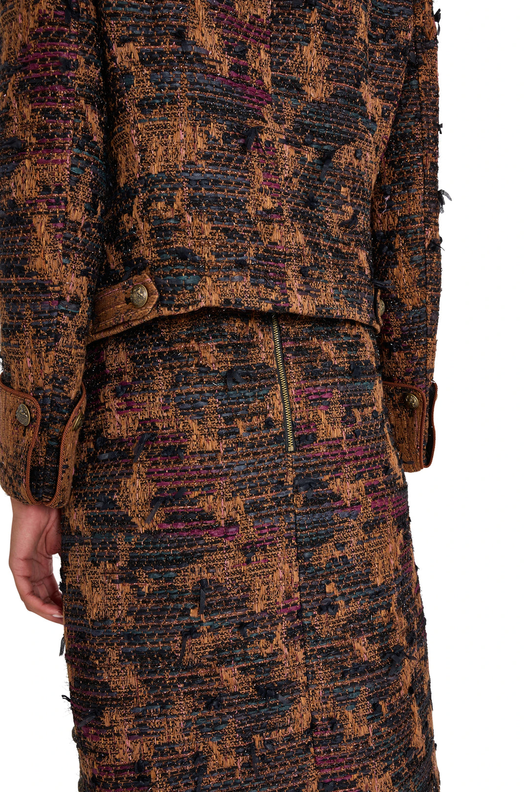 Detail of Olsen Tweed Skirt showing tweed fabric texture, brown cuffs, and exposed back zipper; detail view.