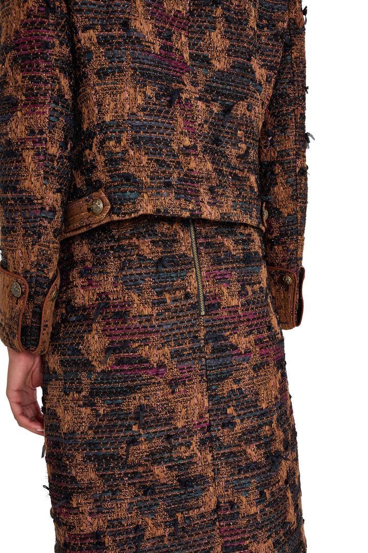 Detail of Olsen Tweed Skirt showing tweed fabric texture, brown cuffs, and exposed back zipper; detail view.